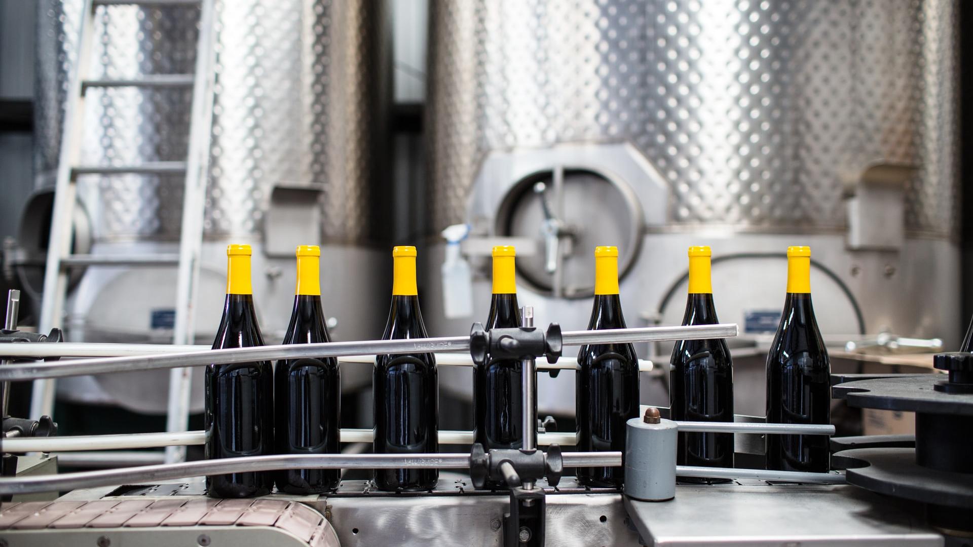 black glass bottles on stainless steel rack